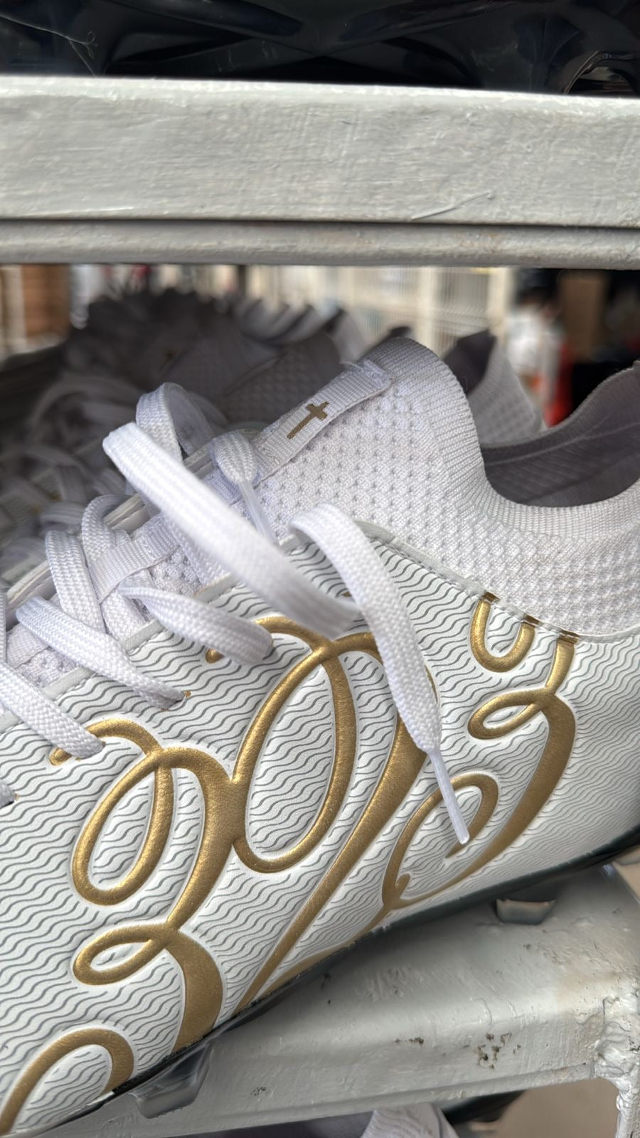 323 Cleats gold script close-up